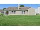 Home's backyard featuring a well-maintained lawn, siding, and sliding glass door at 7456 Jack Pine Ct, Avon, IN 46123