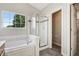 Bright bathroom featuring a soaking tub, shower, and a large window with natural light at 7456 Jack Pine Ct, Avon, IN 46123