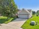 Home's inviting exterior with a brick facade, mature tree and a two-car garage on a sunny day at 7456 Jack Pine Ct, Avon, IN 46123