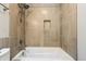 Close-up view of a modern shower-tub combo featuring tiled walls and a shower niche at 7456 Jack Pine Ct, Avon, IN 46123