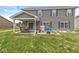 Back patio features outdoor seating, hanging plants and an adjacent play area in the well-manicured yard at 7603 Merrick Dr, Brownsburg, IN 46112
