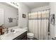 Neutral bathroom with a vanity, mirror, and a shower with a patterned curtain at 7603 Merrick Dr, Brownsburg, IN 46112