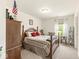 This bedroom features a wood bed frame, a neutral color scheme, and natural light from a window at 7603 Merrick Dr, Brownsburg, IN 46112