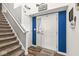 Entryway with stairs, a blue accent wall, and a 'Welcome Happy' doormat on hardwood floors at 7603 Merrick Dr, Brownsburg, IN 46112