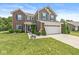 Two-story home featuring brick and vinyl siding, a well-kept lawn, and mature landscaping at 7603 Merrick Dr, Brownsburg, IN 46112