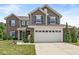 Charming two-story home with a brick and vinyl exterior, well-manicured lawn, and an attached two-car garage at 7603 Merrick Dr, Brownsburg, IN 46112