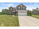 Attractive two-story home with a two-car garage, manicured lawn, and a playset visible in the yard at 7603 Merrick Dr, Brownsburg, IN 46112