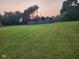 Wide shot of a backyard with grass, storage container and setting sun at 7870 E County Road 150 S, Avon, IN 46123