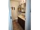 Bathroom with wood vanity, white sink and commode, and decorative storage at 7870 E County Road 150 S, Avon, IN 46123