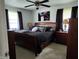 Bedroom with a ceiling fan, carpet, and a wooden bed frame with neutral walls and black out curtains at 7870 E County Road 150 S, Avon, IN 46123