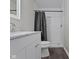 Bathroom featuring a white vanity, a white subway-tiled shower, and gray walls at 802 N Tuxedo St, Indianapolis, IN 46201