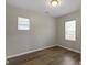 This bedroom features hardwood floors, neutral paint, two windows, and a ceiling light at 802 N Tuxedo St, Indianapolis, IN 46201