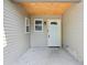 Covered front porch with light-toned siding and trim, a white front door, and a window at 802 N Tuxedo St, Indianapolis, IN 46201