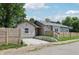Quaint home featuring a tandem driveway and natural wood fence, nestled among mature trees and greenery at 802 N Tuxedo St, Indianapolis, IN 46201