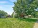 Spacious front yard featuring lush green grass and a mature shade tree partially obscuring the charming two-story home at 812 Timber Creek Dr, Indianapolis, IN 46239