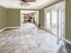 Bright living room with tile floors, an open kitchen view, and access to a sunroom through elegant French doors at 812 Timber Creek Dr, Indianapolis, IN 46239