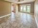 Bright living room with tile flooring, a ceiling fan, and large windows offering ample natural light at 812 Timber Creek Dr, Indianapolis, IN 46239
