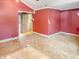 Spacious living room featuring light-colored baseboards and red walls ready for renovation with bright natural light at 812 Timber Creek Dr, Indianapolis, IN 46239