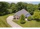 Aerial view of the house with a long driveway, manicured lawn, and lush trees at 815 Copperfield Ln, Danville, IN 46122