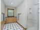 Bathroom with shower, cabinet space, patterned flooring, towel racks, and a window with a view of the outside at 815 Copperfield Ln, Danville, IN 46122