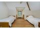 Bright bedroom with two beds, hardwood floors, ceiling fan, window, and white walls at 815 Copperfield Ln, Danville, IN 46122