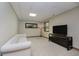 Simple Living Room with a white couch, TV and stand, a large mirror, a window, and carpeted floors at 815 Copperfield Ln, Danville, IN 46122