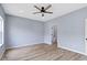 A spacious bedroom is painted light blue and features a ceiling fan and wood-look flooring at 8355 Fieldfare Way, Indianapolis, IN 46237