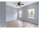 Bedroom featuring wood-look flooring, neutral paint, and two windows for natural light at 8355 Fieldfare Way, Indianapolis, IN 46237