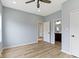 Bedroom with wood-look flooring, neutral paint, and a view of a connected bathroom at 8355 Fieldfare Way, Indianapolis, IN 46237