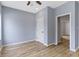 Bright bedroom with wood-look flooring, a modern ceiling fan, and neutral-toned walls at 8355 Fieldfare Way, Indianapolis, IN 46237