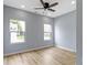 Bedroom showcasing dual windows with neighborhood views, wood-look flooring, and a ceiling fan at 8355 Fieldfare Way, Indianapolis, IN 46237