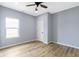 Bedroom featuring wood-look floors, a window with a view, and a modern ceiling fan at 8355 Fieldfare Way, Indianapolis, IN 46237