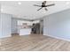 Open-concept living area with wood-look floors, ceiling fan, and modern kitchen featuring white cabinets at 8355 Fieldfare Way, Indianapolis, IN 46237