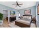 Comfortable main bedroom featuring a wood frame bed, ceiling fan, and ensuite bathroom at 8355 Fieldfare Way, Indianapolis, IN 46237