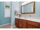 Traditional powder room with wood vanity, framed mirror, and pale blue walls at 9399 Irishmans Run Ln, Zionsville, IN 46077
