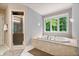 Bathroom featuring a separate shower, tub, and a window providing natural light at 9399 Irishmans Run Ln, Zionsville, IN 46077