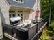 Relaxing outdoor deck with patio furniture, string lights, and wooded scenery at 9399 Irishmans Run Ln, Zionsville, IN 46077