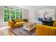 Bright living room features a large window with backyard views and contemporary yellow furniture at 9399 Irishmans Run Ln, Zionsville, IN 46077