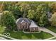Aerial view of a well-maintained brick home with green lawn and surrounding trees at 9703 Fortune Dr, Fishers, IN 46037