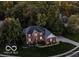 Aerial view of a brick two-story home with a well-manicured lawn and mature trees at 9703 Fortune Dr, Fishers, IN 46037