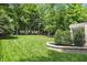 Expansive backyard featuring manicured lawn, mature trees, and brick landscaping at 9703 Fortune Dr, Fishers, IN 46037