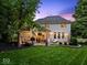 Expansive backyard featuring a stone patio with outdoor seating, grill and lush landscaping at 9703 Fortune Dr, Fishers, IN 46037