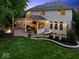 Backyard featuring a covered patio with string lights and a fire pit area at 9703 Fortune Dr, Fishers, IN 46037