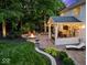 Backyard featuring a covered patio with string lights and a fire pit area at 9703 Fortune Dr, Fishers, IN 46037
