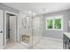 Contemporary bathroom showcasing a glass shower with marble tiling, a window, and a wood stool at 9703 Fortune Dr, Fishers, IN 46037