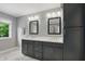 Bathroom featuring a double vanity, two mirrors, and a sunlit window with a serene view at 9703 Fortune Dr, Fishers, IN 46037