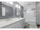 Modern bathroom featuring double vanity and subway-tiled shower with sliding glass door at 9703 Fortune Dr, Fishers, IN 46037