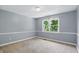 Cozy bedroom featuring neutral walls, trim, and a large sunny window at 9703 Fortune Dr, Fishers, IN 46037