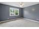 Cozy bedroom with soft carpet, ceiling fan, and bright window offering natural light and pleasant views at 9703 Fortune Dr, Fishers, IN 46037