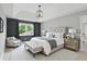 A beautifully staged bedroom with a tray ceiling, stylish furnishings, and a large window with natural light at 9703 Fortune Dr, Fishers, IN 46037